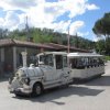 Trenino bianco fermo su strada acciottolata.