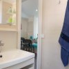 Interno di un bagno, lavandino bianco, specchio, asciugamano blu appeso.