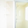 Cabina doccia con porte scorrevoli e finestra accanto.