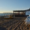 Spiaggia con stabilimento e pedalò al tramonto.