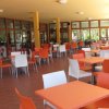 Un ristorante all'aperto con tavoli arancioni e bianchi, circondato da colonne gialle.