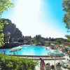 Una piscina con ombrelloni colorati e persone a bordo vasca.