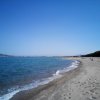 Una spiaggia deserta con sabbia e mare cristallino.