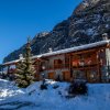 Chalet di montagna con neve e cielo blu.
