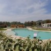Piscina all'aperto circondata da vegetazione.