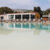 Vista su piscina con edificio moderno sullo sfondo.