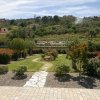 Giardino con vialetto e colline sullo sfondo.