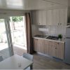 Cucina moderna con tavolo e porta-finestra aperta.