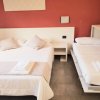 Letto matrimoniale e singolo con parete rossa dietro.
