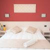 Camera da letto con parete rossa e letto matrimoniale.