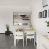Cucina moderna con tavolo e sedie bianche.