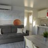 Interno moderno con divano, cucina e decorazione marittima.