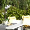 Terrazza con sedie gialle, tavolo e piante.