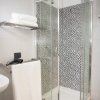 Bagno con doccia in vetro e asciugamani.