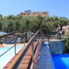Piscina con un ponte e ombrelloni blu in un parco acquatico.