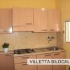 Cucina con mobili chiari e finestra.