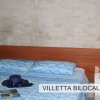 Camera con letto matrimoniale e copriletto blu.