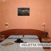 Camera con parete rosa e letto matrimoniale.