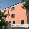 Edificio arancione con finestre ad arco.