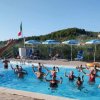 Lezione di acquagym in piscina con persone e istruttrice.