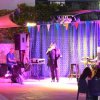 Concerto dal vivo su un palco illuminato con musicisti.