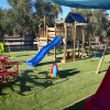 Parco giochi con scivoli e altalene colorate.