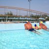 Tre persone in una piscina all'aperto di giorno.