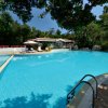 Ampia piscina con casa bianca sullo sfondo.