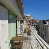Balcone con sedie e tavolini, vista urbana.
