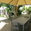 Pergolato con tavolo e barbecue in giardino.