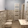 Bagno con wc, bidet e lavabo su parete decorata.