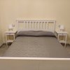 Letto matrimoniale con comodini e lampade.