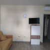 Salotto con divano beige e TV a parete.