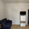Soggiorno con divano blu e televisore appeso al muro.
