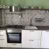 Cucina con piastrelle decorative, piano cottura e lavandino.