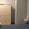 Armadio bianco e parte di un letto con copriletto blu.