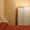 Armadio bianco e letto con copriletto rosso.