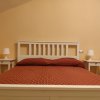 Letto matrimoniale con copriletto rosso.