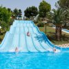 Scivoli d'acqua blu con persone che scivolano in piscina.