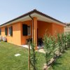 Casa arancione con giardino recintato da siepi.