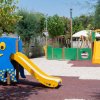 Parco giochi con scivolo a forma di polpo e strutture colorate.