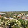 Vista panoramica di un borgo con case e vegetazione collinare.