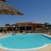 Piscina esterna con ombrellone e edificio sullo sfondo.