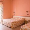 Camera con due letti e pareti rosa.