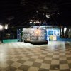 Sala con pavimento a scacchi e piccolo palco.