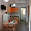 Cucina moderna con mobili arancioni e tavolo apparecchiato.