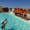 Gruppo in piscina posa per una foto.