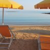 Spiaggia con lettini e ombrelloni gialli.