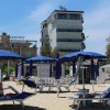 Ombrelloni blu e lettini su una spiaggia sabbiosa.