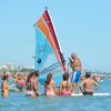 Persone in mare con una tavola a vela.